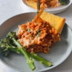Skillet lasagna served with broccolini and garlic bread.