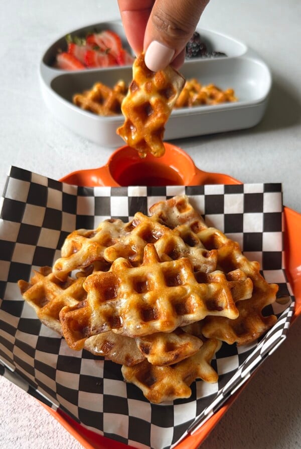 Bacon waffles served with berries and maple syrup.