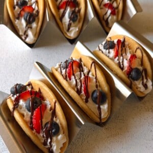 Pancake tacos served with whipped cream, berries and a chocolate drizzle.
