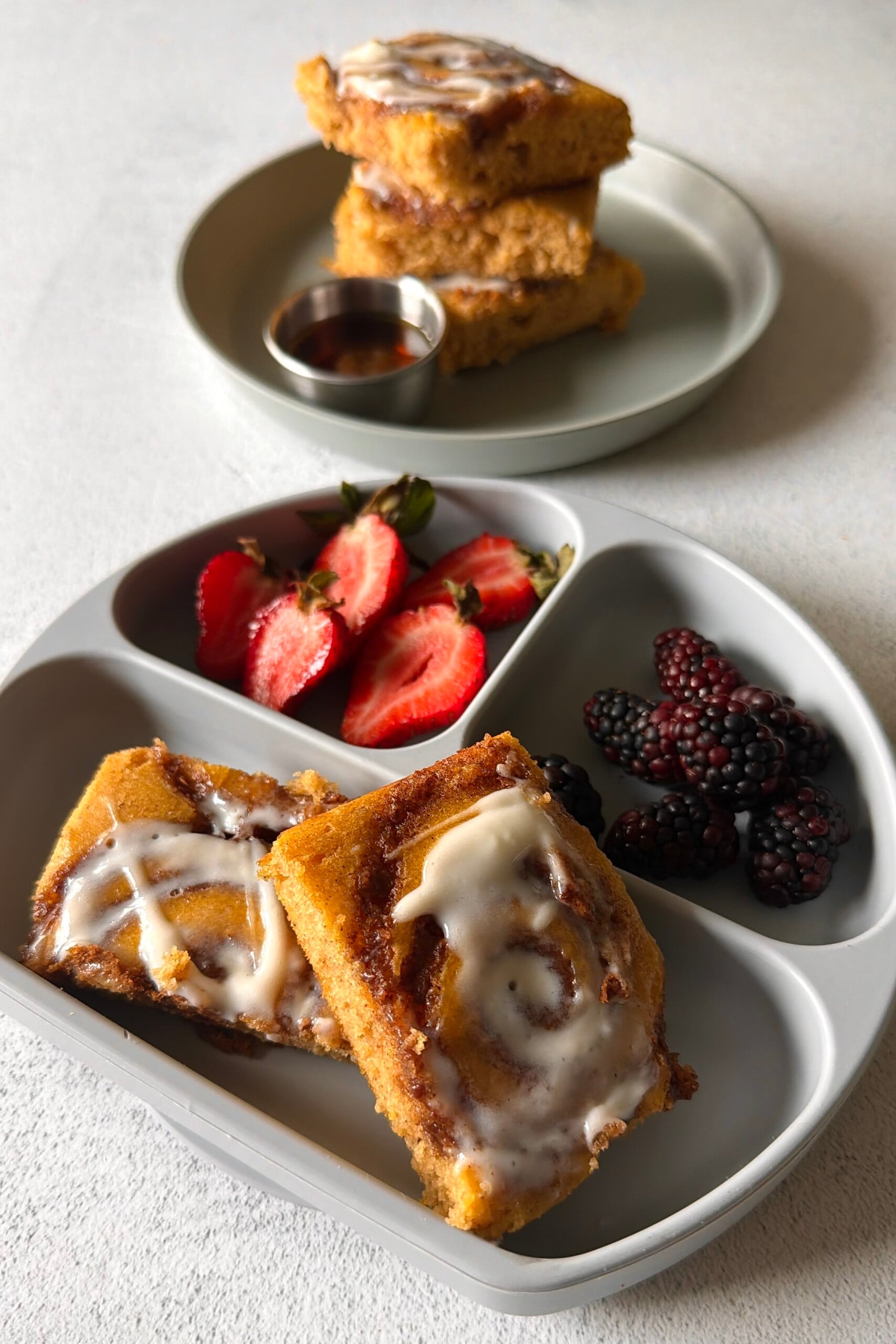 Pumpkin cinnamon roll sheet pan pancakes served with berries.