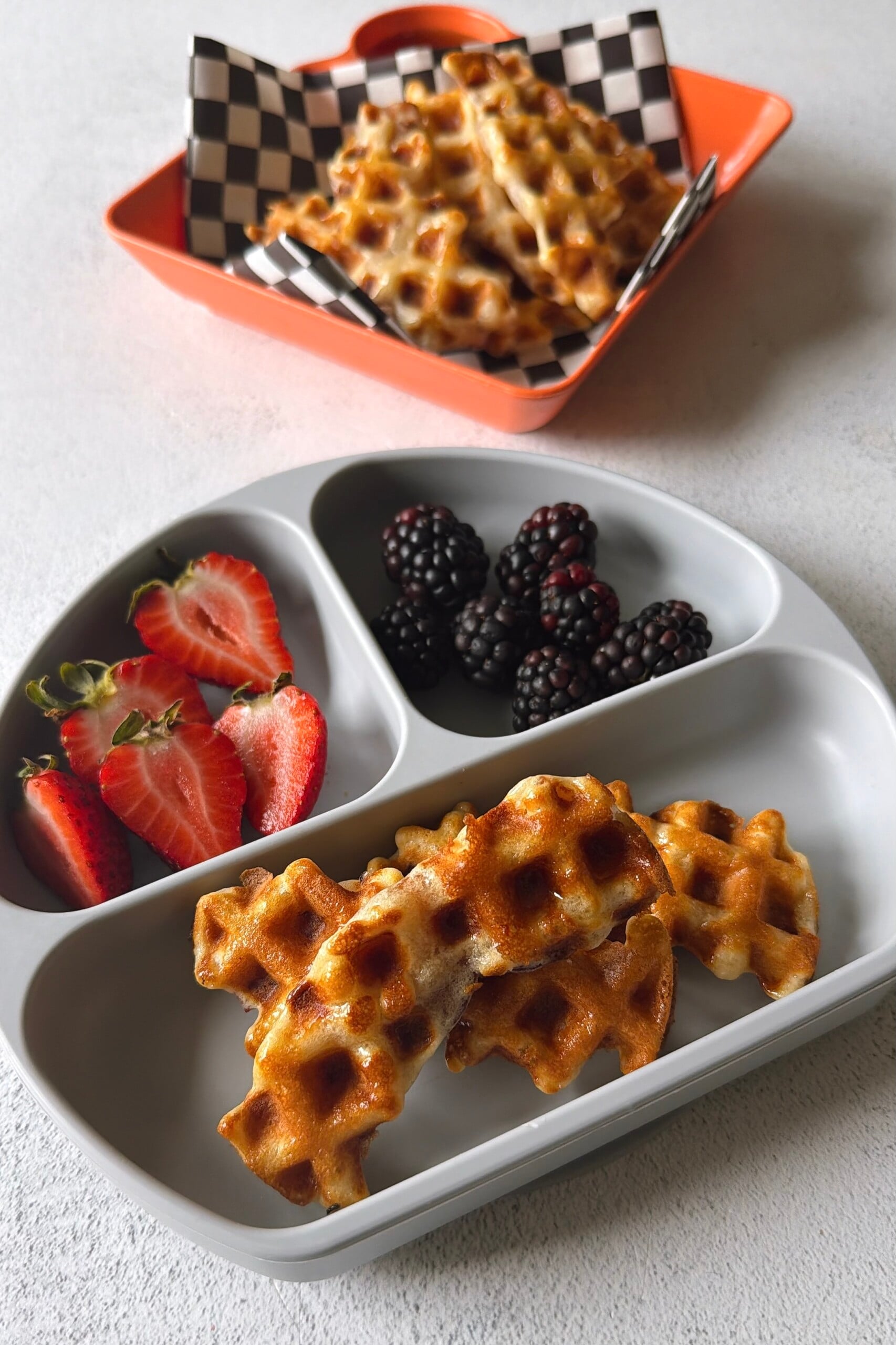Bacon waffles served with berries and maple syrup.