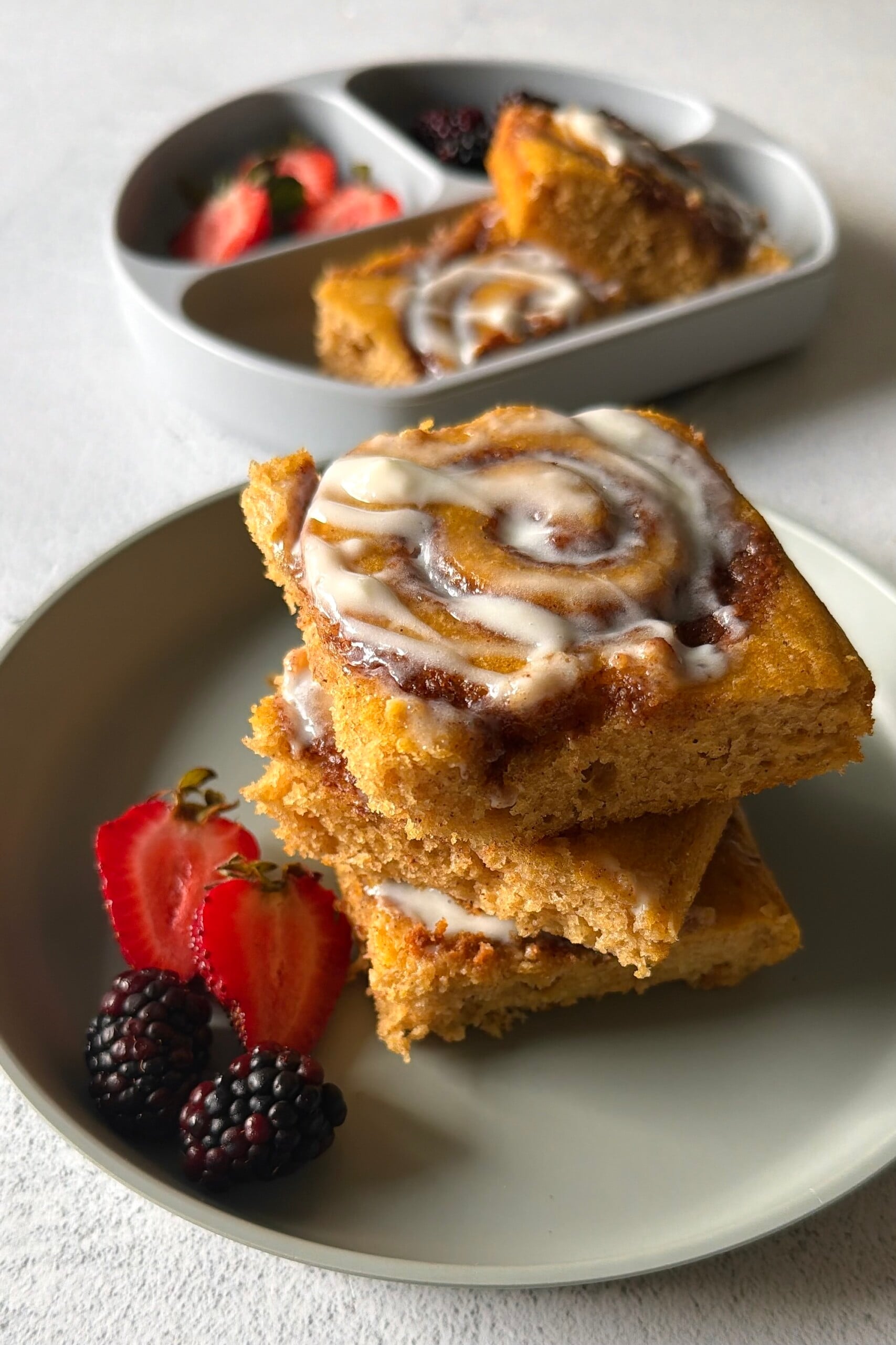 Pumpkin cinnamon roll sheet pan pancakes served with berries.