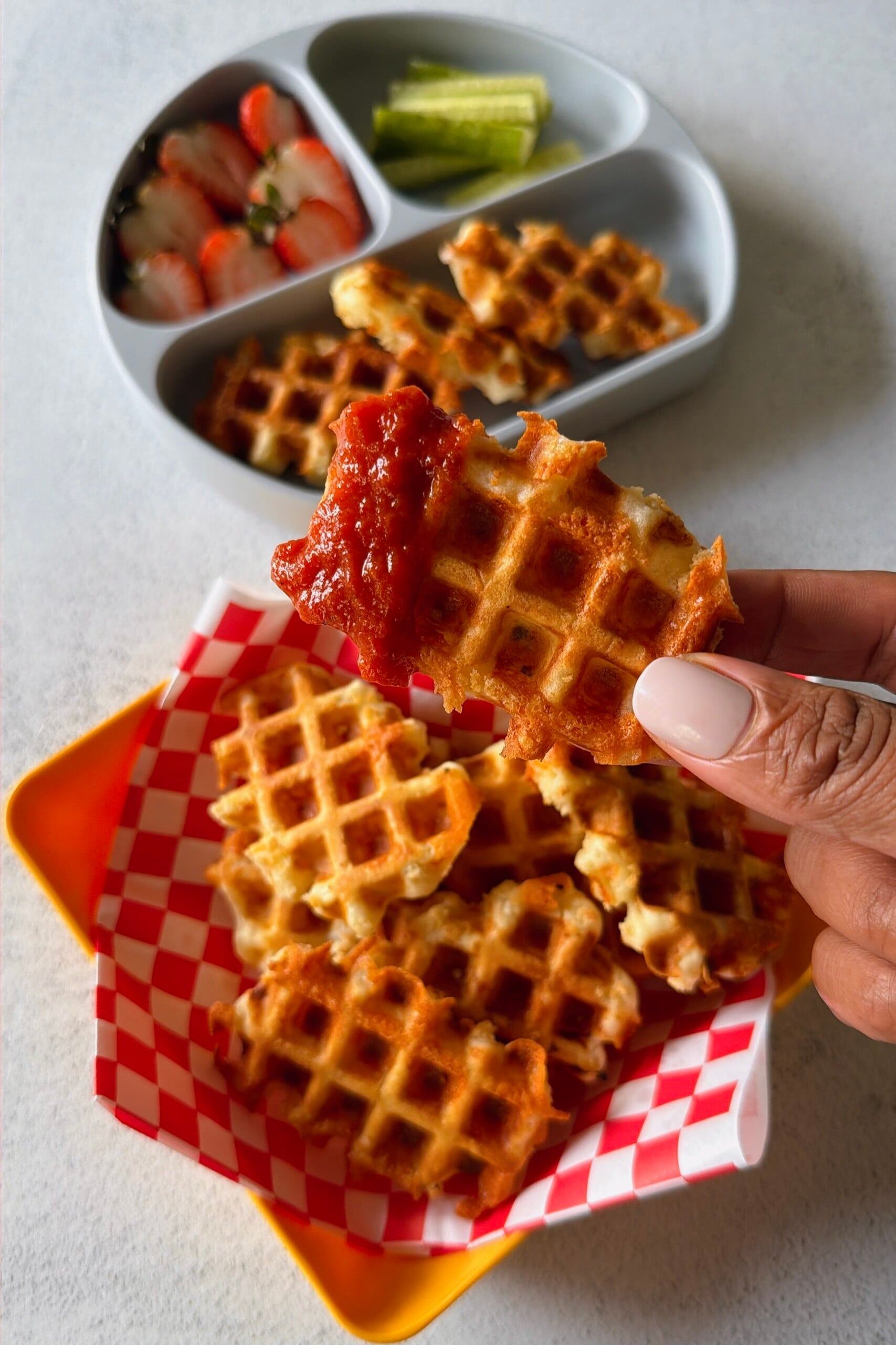 Mozzarella stick waffles served with marinara sauce.